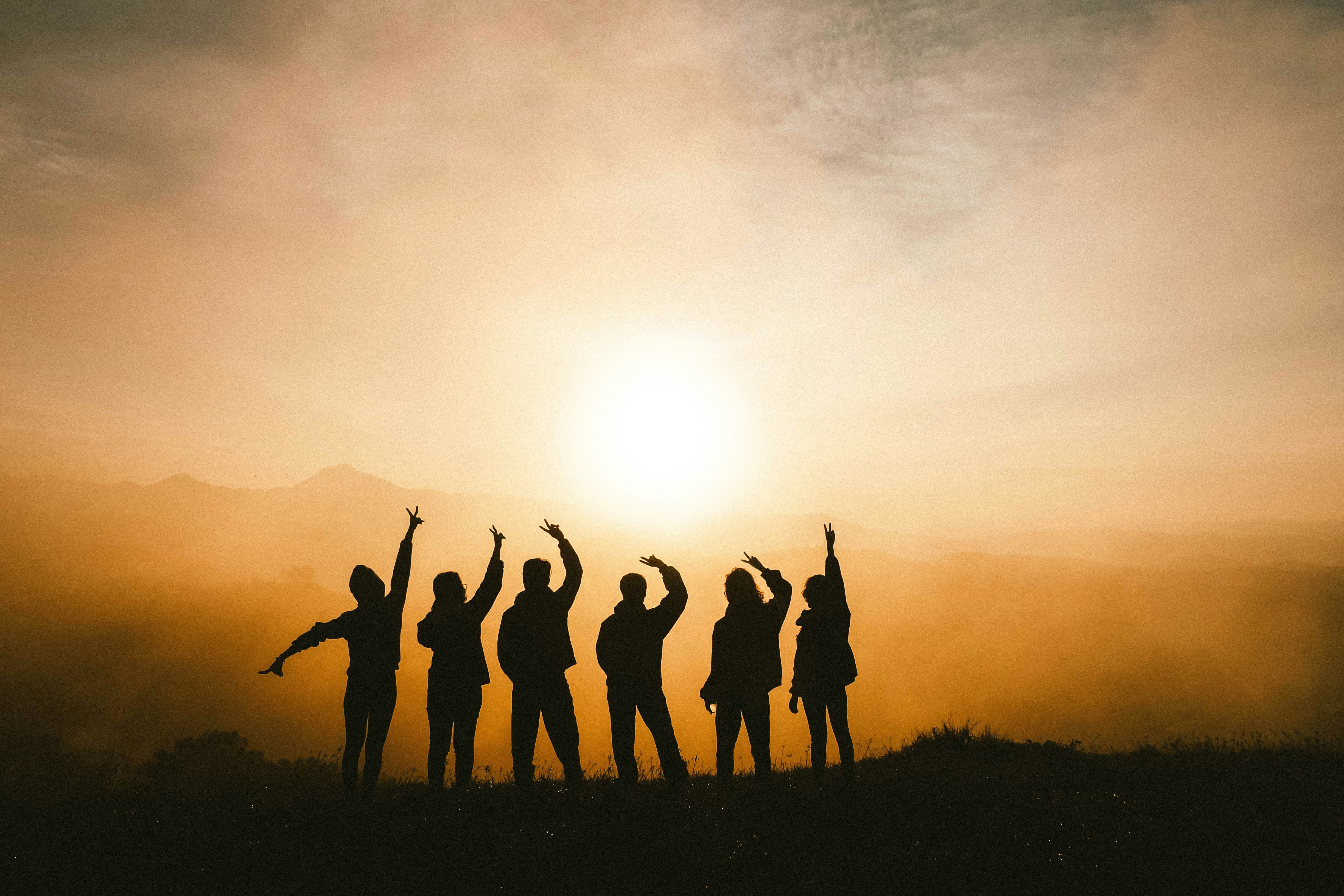 Team members celebrating together in a sunrise