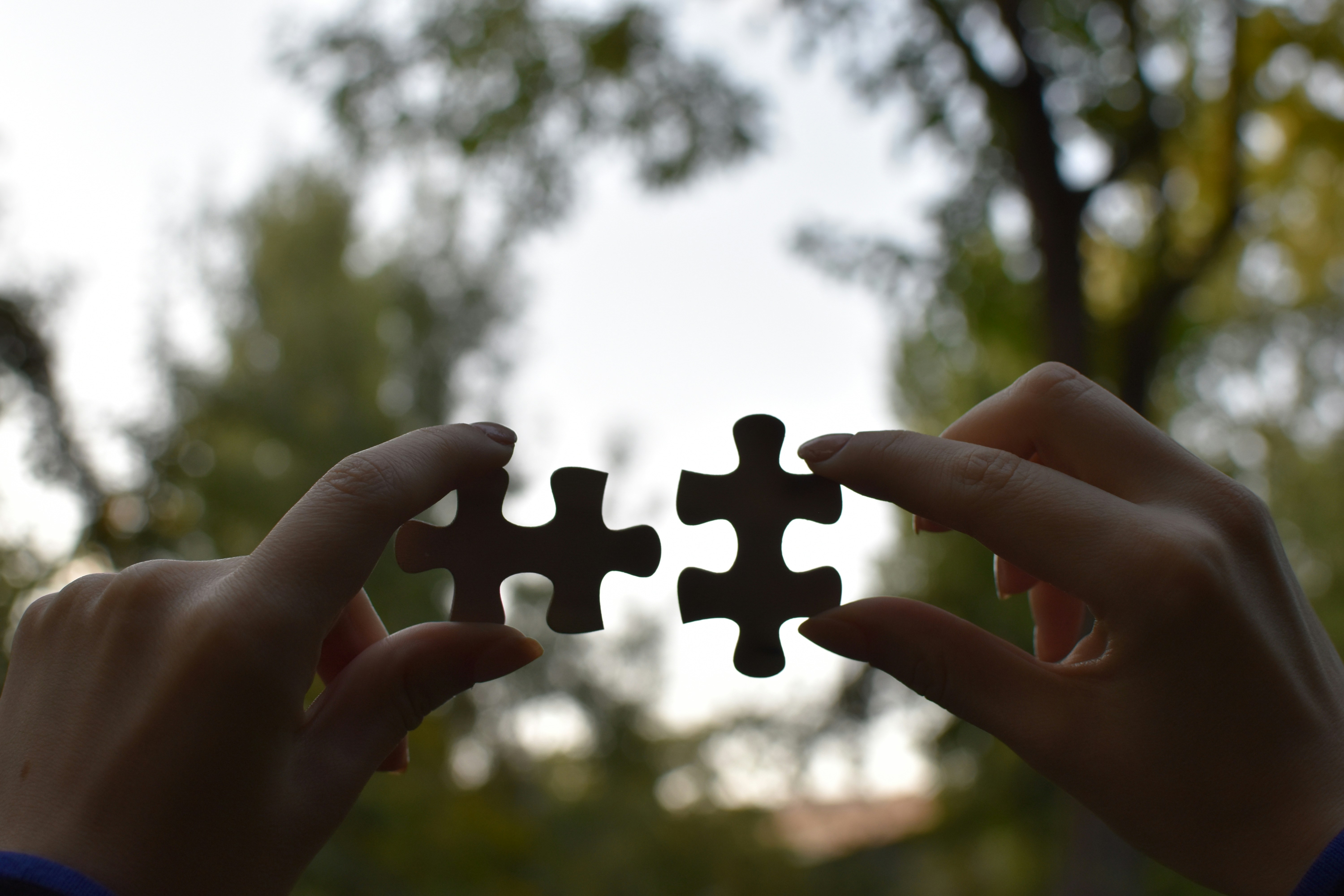 Two people connecting puzzle pieces