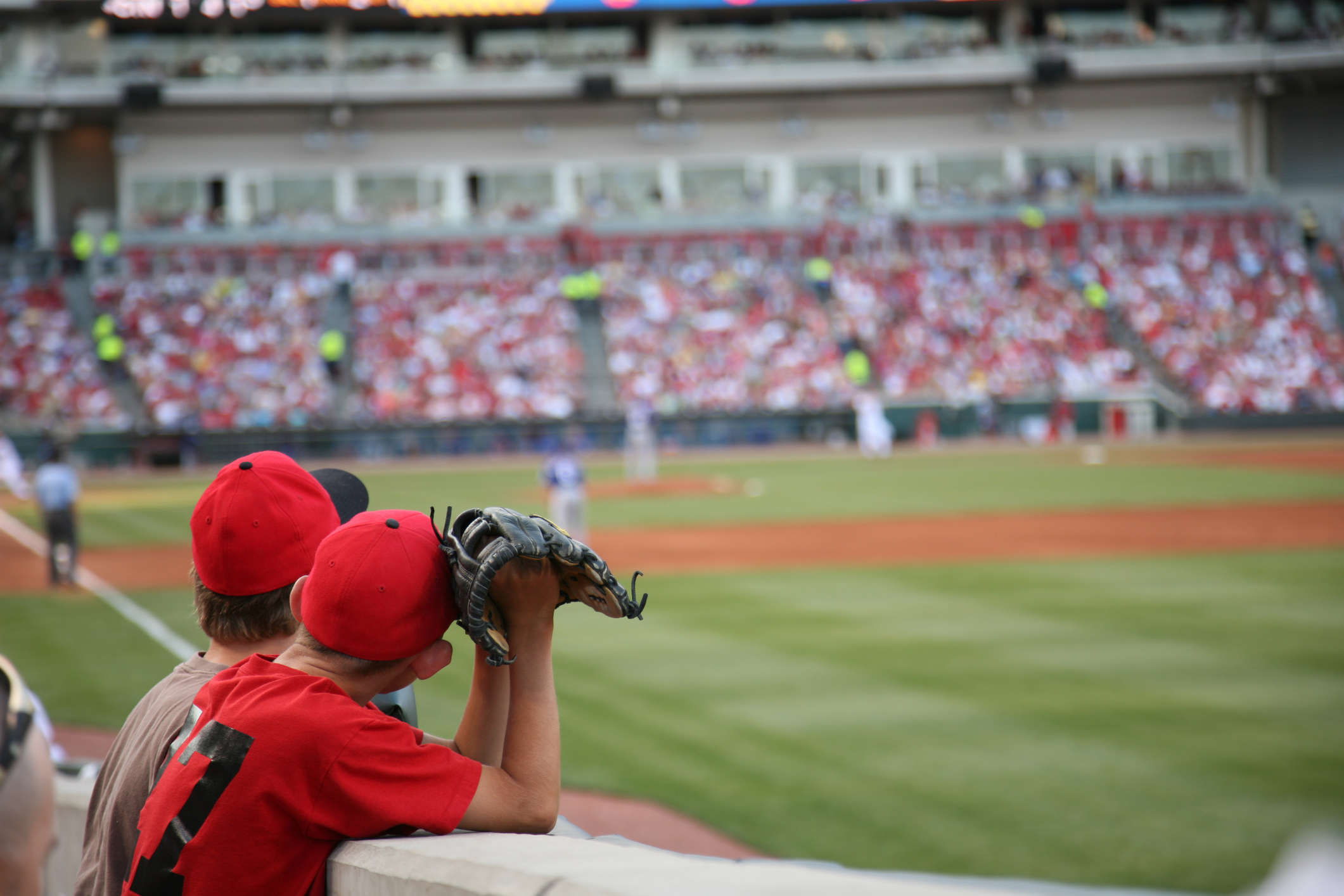 Two people at a baseball game, one with a glove in his hand.